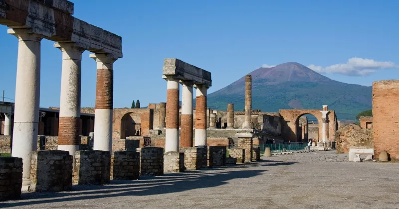 Private guide with a group of eight travellers beside the ancient walls at the Pompeii entrance on a priority-entry tour