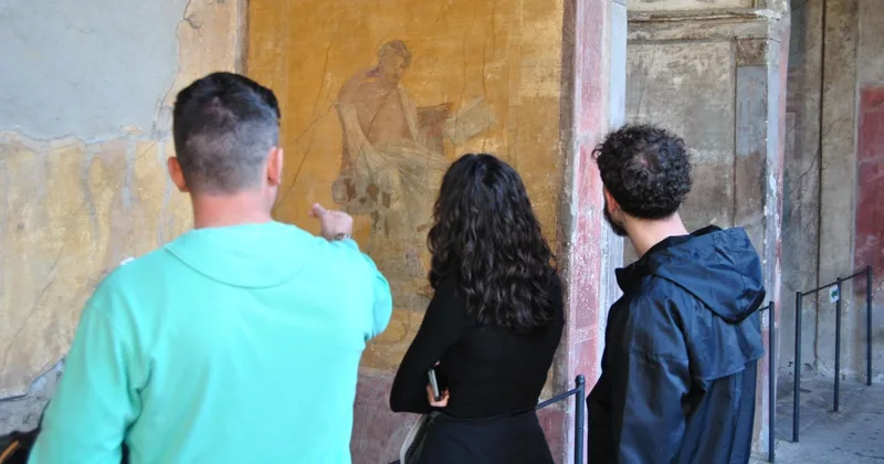 Guide opening the way into the Pompeii excavations at Porta Marina for a private group with entry included